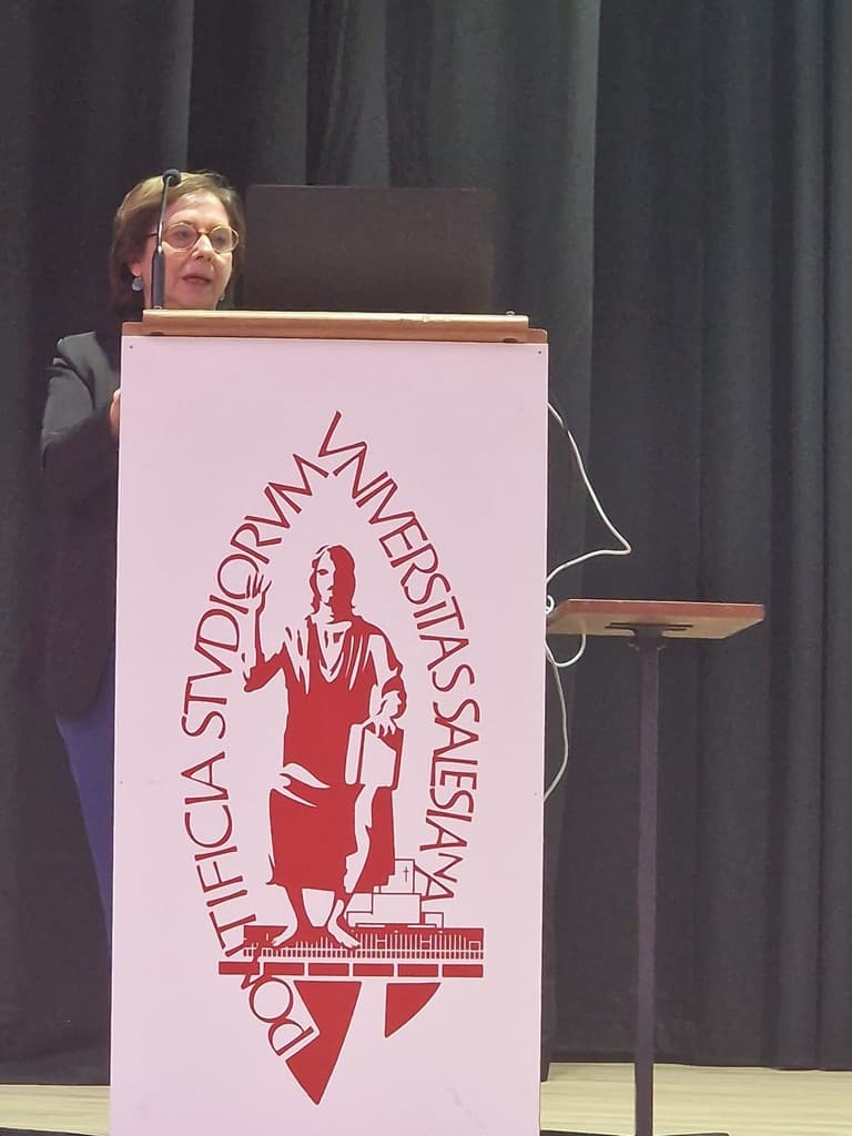 Relatore al podio con lo stemma Pontificia Studiorum Universitas Salesiana